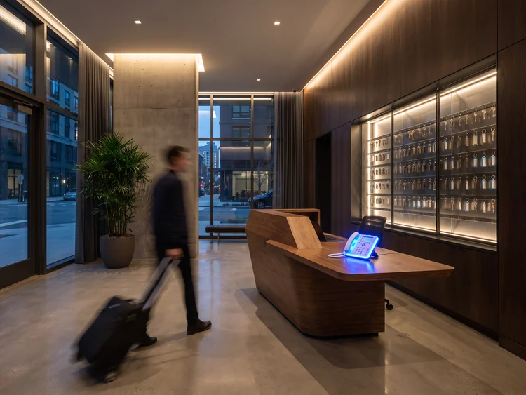 Apartment lobby at night with a guest walking past the leasing desk
